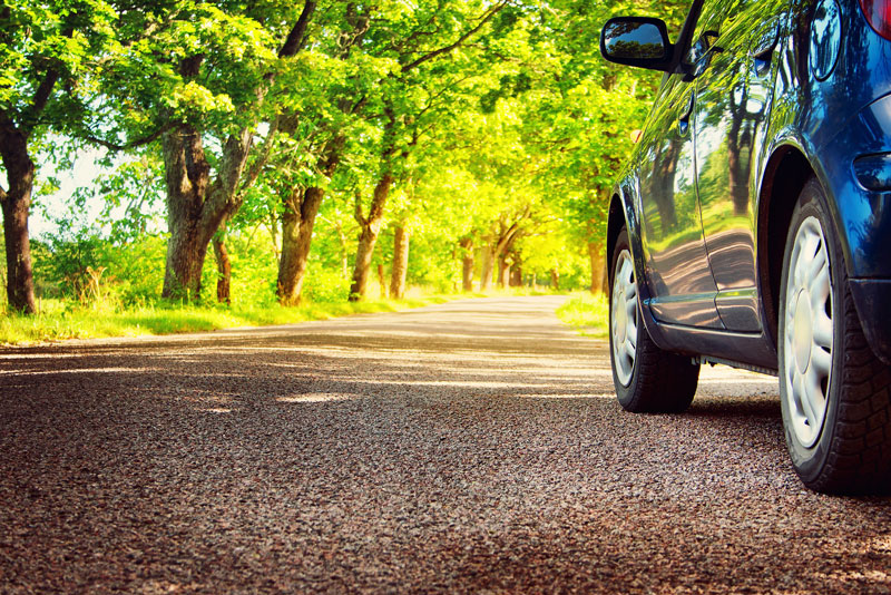 a car driving on a summer road