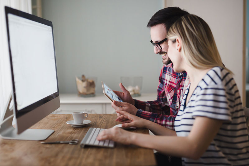 a young couple looking at a computer