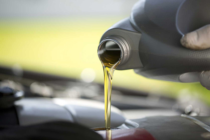 pouring oil into a car